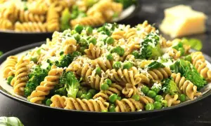 Pyszny makaron z groszkiem i brokułami, posypany parmezanem. Idealny na lekki obiad.