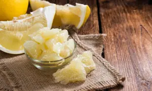 Soczyste kawałki pomelo w miseczce i obok, pokazujące, jak jeść ten owoc.