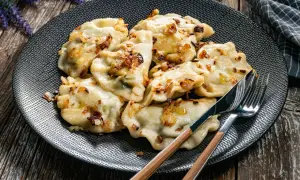 Pyszne pierogi z cebulką na talerzu. Czy rozmrażać pierogi przed gotowaniem? Zobacz, jak wyglądają gotowe!