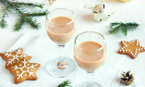 Dwa kieliszki z kremowym likierem nutella, ozdobione świątecznymi pierniczkami i gałązkami świerku.