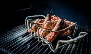 Żeberka w stojaku na grillu, gotowe na prawdziwy barbecue po polsku. Soczyste mięso pieczone na ruszcie.