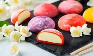 Kolorowe japońskie desery mochi, otoczone białymi kwiatami jaśminu, kuszą swoim wyglądem i smakiem.