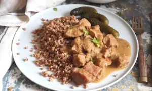 Pyszny gulasz z szynki podany z kaszą gryczaną i ogórkami kiszonymi. Aromatyczne danie, które zachwyci każdego smakosza.