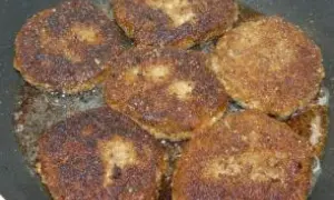 Smażone kotlety z grzybów w panierce, rumiane i apetyczne, skwierczą na patelni.