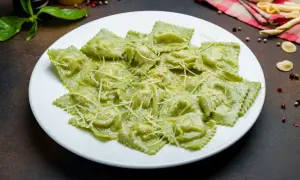 Pyszne ravioli ze szpinakiem i ricottą, polane kremowym sosem i posypane parmezanem. Idealne na lekki obiad.