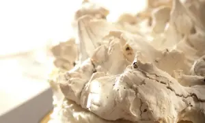 Puszysty krem dakłas z kawałkami czekolady, tworzący górskie szczyty na torcie.