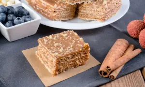 Pyszne wafle z kajmakiem, posypane orzechami, obok jagody, liczi i laski cynamonu.