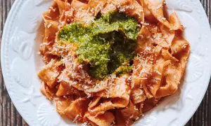 Pappardelle all'arrabbiata przepis: szeroki makaron z pikantnym sosem pomidorowym, zielonym pesto i parmezanem.