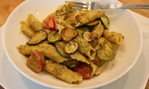 Pyszne makaron garganelli z cukinią i pomidorkami w sosie pesto.