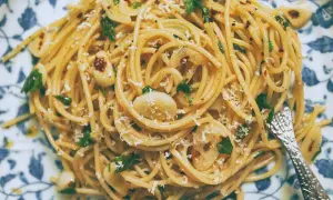 Pyszne spaghetti aglio olio z czosnkiem, natką pietruszki i płatkami chili, posypane parmezanem.