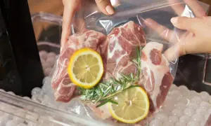 Mięso wieprzowe z cytryną i rozmarynem w woreczku do metody sous vide, gotowe do kąpieli wodnej.