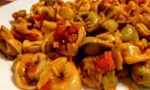 Pyszne tortellini z pomidorami i mozzarellą w sosie, danie gotowe do podania.