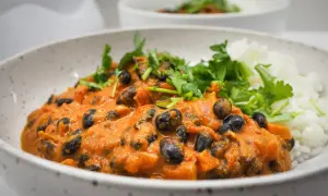 Pyszna fasola masala w kremowym sosie pomidorowym, podana z ryżem i świeżą kolendrą.