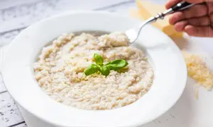 Kremowe risotto bianco z parmezanem i bazylią, gotowe do zjedzenia.