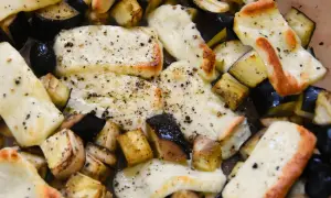 Pyszne halloumi z piekarnika, zapieczone z kawałkami bakłażana, posypane świeżo mielonym pieprzem. Idealne danie.