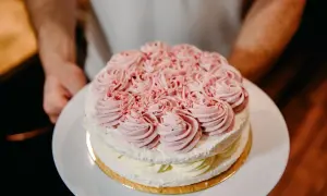 Dwupoziomowy tort lodowo bezowy z różową dekoracją z kremu. Idealny na letnie przyjęcie, oto przepis!