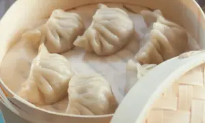 Pyszne pierożki na parze w bambusowym parowniku, gotowe do podania.