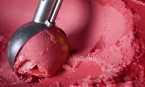 Łyżka do lodów nabiera porcję orzeźwiającego sorbetu z arbuza. Idealny na upalne dni.