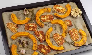 Pieczona dynia piżmowa z serem halloumi i czosnkiem na blasze.