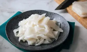 Płaski, biały makaron ryżowy na talerzu, gotowy do przygotowania pysznych dań. Szukasz inspiracji? Sprawdź makaron vermicelli przepisy!