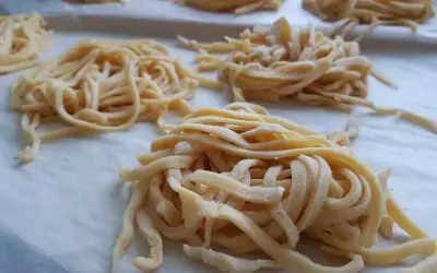 Świeże, domowe tagliatelle uformowane w gniazda. Zastanawiasz się, ile jajek do makaronu? Te wyglądają na idealne!