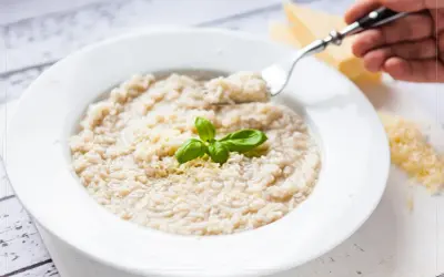 Kremowe risotto bianco z parmezanem i bazylią, gotowe do zjedzenia.