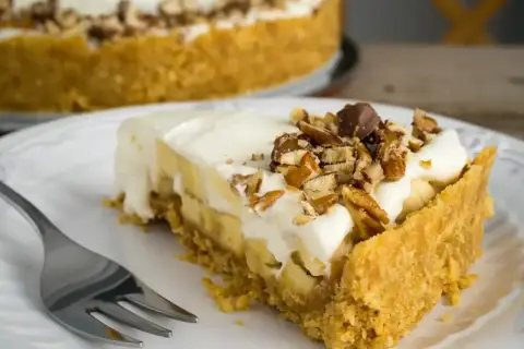 Pyszny kawałek fit banoffee z bananami, bitą śmietaną i orzechami. Idealny deser dla dbających o linię.
