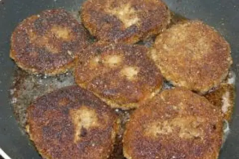 Smażone kotlety z grzybów w panierce, rumiane i apetyczne, skwierczą na patelni.