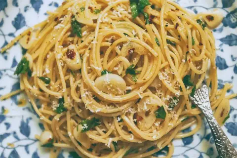Pyszny makaron z oliwą i czosnkiem, posypany parmezanem i natką pietruszki. Idealny na szybki obiad.