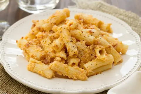 Penne po włosku z kremowym sosem i kawałkami boczku, posypane parmezanem i pieprzem.