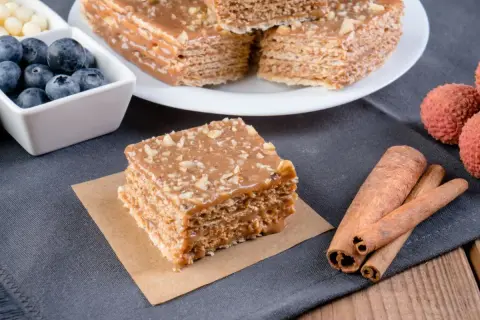 Pyszne wafle z kajmakiem, posypane orzechami, obok jagody, liczi i laski cynamonu.