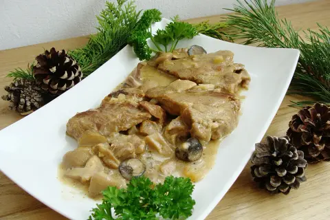Karkówka w sosie grzybowym, podana z gałązkami iglaków i szyszkami, wygląda apetycznie.