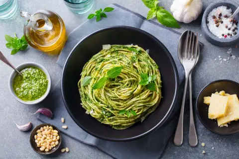 Pyszny piątkowy obiad bez mięsa: spaghetti z pesto, świeżą bazylią, orzeszkami pinii i parmezanem. Idealny na lekki posiłek.