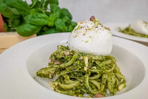 Makaron z pesto pistacjowym i burratą, posypany posiekanymi pistacjami. Pyszne danie, które zachwyca smakiem i wyglądem.