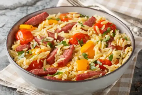Pyszne danie z makaronem orzo, pomidorkami, papryką i kiełbasą. Idealny orzo przepis na szybki obiad.