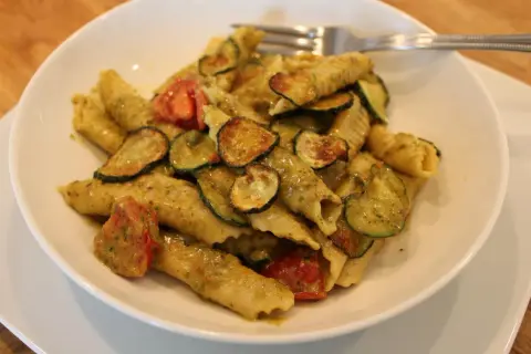 Pyszne makaron garganelli z cukinią i pomidorkami w sosie pesto.
