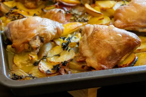 Złocisty kurczak pieczony z ziemniakami i ziołami w blasze. Aromatyczne danie, które zachwyca smakiem.