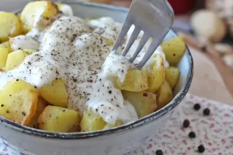 Ziemniaki z sosem śmietanowym i pieprzem, jak spaghetti z pieprzem. Widelec nabiera porcję ziemniaków.