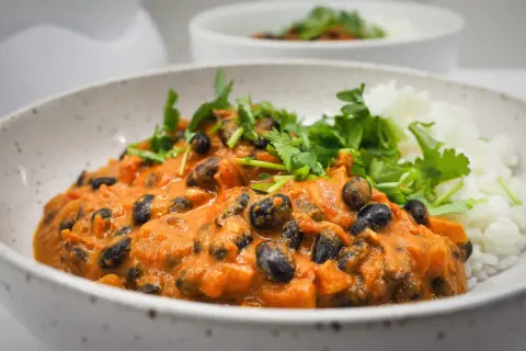 Pyszna fasola masala w kremowym sosie pomidorowym, podana z ryżem i świeżą kolendrą.