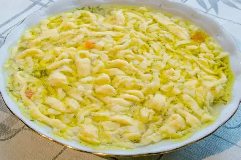 Pyszne kluski do zupy grzybowej, delikatne i domowe, pływające w aromatycznym bulionie.