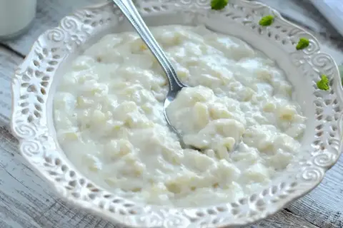 Pyszna, kremowa zupa mleczna z ryżem, podana w ozdobnej miseczce. Idealna na śniadanie lub deser.