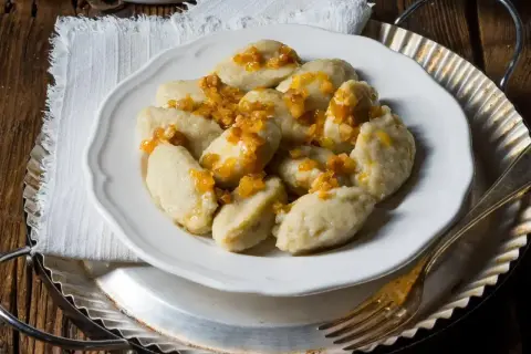 Pyszne kluski śląskie z okrasą, idealne na obiad. Czas gotowania pierogów to chwila, ale te kluski to prawdziwy przysmak!