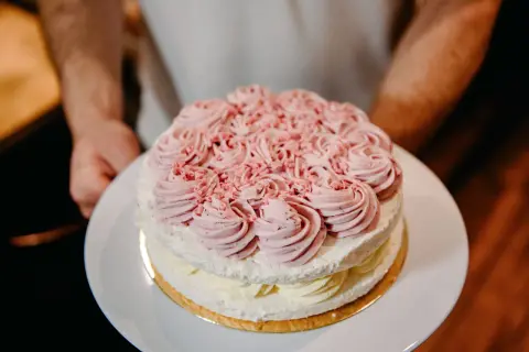 Dwupoziomowy tort lodowo bezowy z różową dekoracją z kremu. Idealny na letnie przyjęcie, oto przepis!