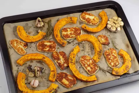 Pieczona dynia piżmowa z serem halloumi i czosnkiem na blasze.