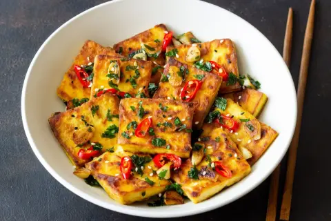 Złocisty, chrupiący tofu zmieniające życie, posypane chili, czosnkiem i sezamem. Pyszne danie, które odmieni Twoje spojrzenie na roślinne jedzenie.