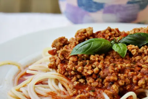 Pyszne spaghetti bolognese z pomidorów, z aromatycznym mięsem mielonym i świeżą bazylią. Idealne na obiad.