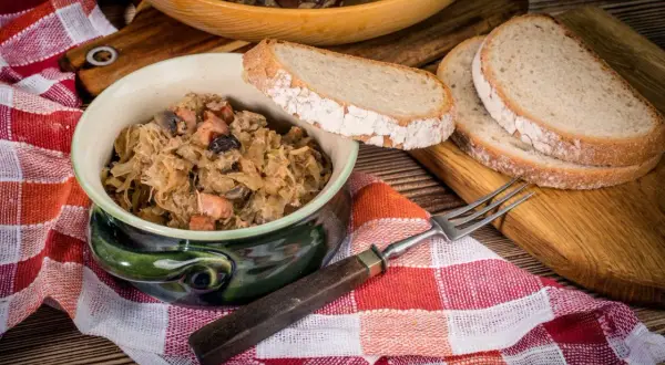 Tradycyjny bigos babci, pachnący kapustą i mięsem, podany z chlebem. Idealny przepis na polskie danie.