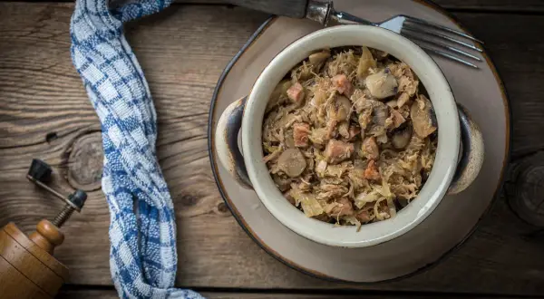 Tradycyjny bigos w glinianym naczyniu, gotowy do podania. Idealny na zimę, a ile gotować bigos, by był pyszny? Długo!