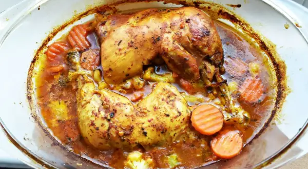 Pyszne udka bez kości w sosie, zapiekane z marchewką i brokułami w szklanym naczyniu.