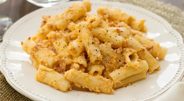 Penne po włosku z kremowym sosem i kawałkami boczku, posypane parmezanem i pieprzem.